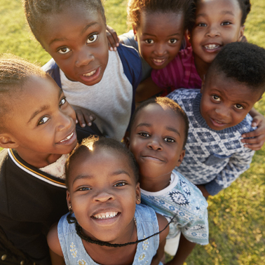 85280648-elementary-school-kids-in-a-field-look-up-at-camera-smiling